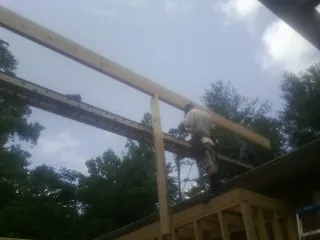 Carpenter setting a ridge beam over a new addition frame — Ice Dam Removal by Roofing Brothers in Maywood